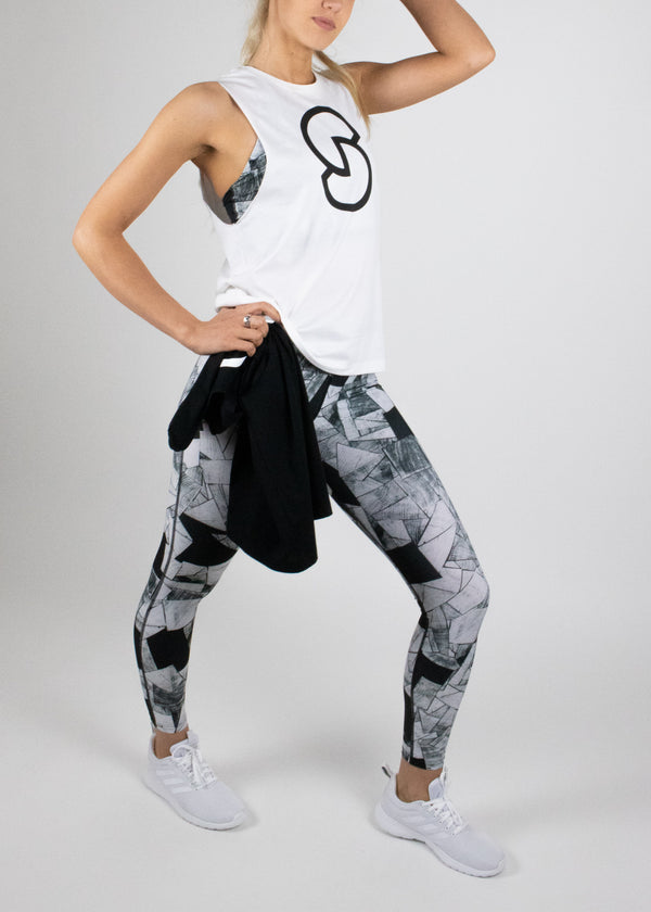 Original Logo tank in white with black Susimust logo at chest worn with the full length Hiiu legging in blkgrain print from Susimust SS19 collection - model shown in full length from side front leaning on left leg